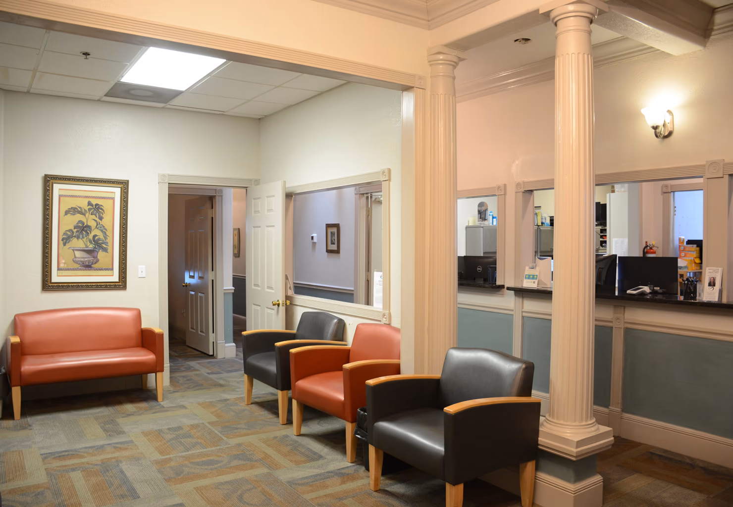 The upstairs waiting room at Aker Eye Downtown, 338 S Washington Ave, Titusville: leather chairs, columns, and the check-in window